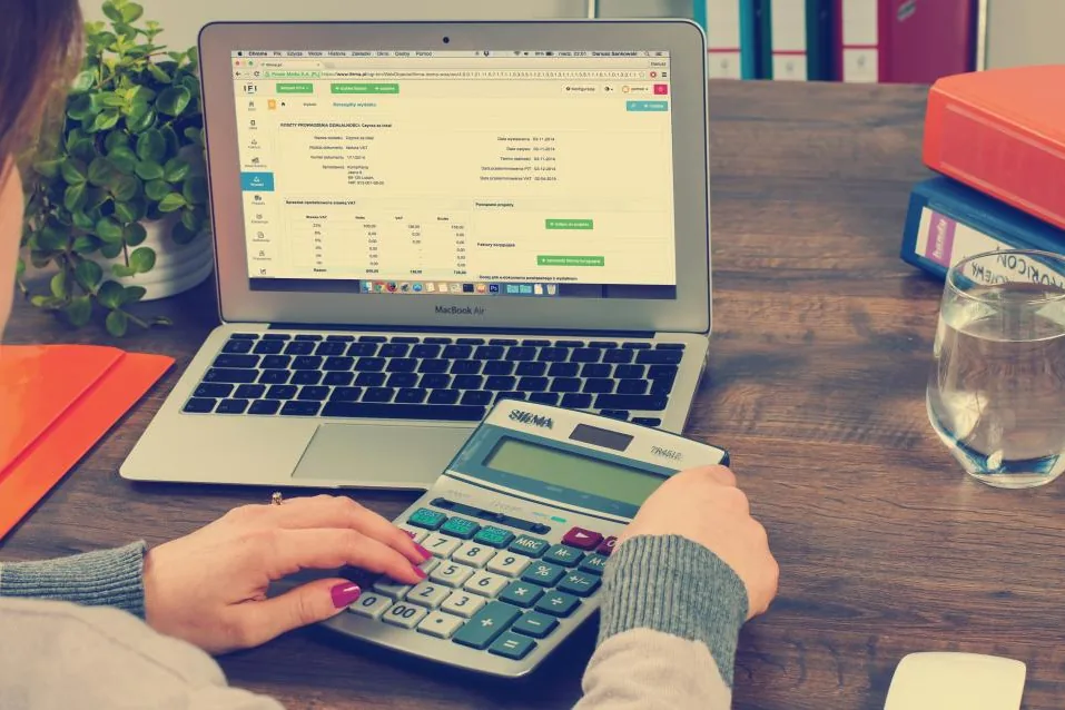 Análisis de números de una empresa con calculadora y computadora